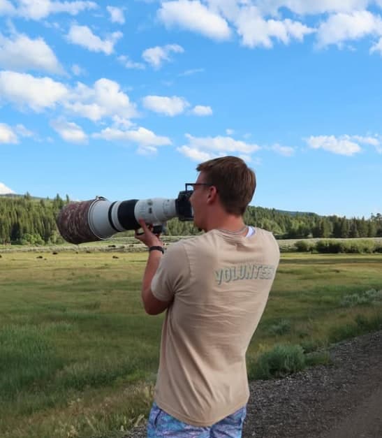 Logan Schulz, founder of The Shot Finder, shooting with a telephoto lens